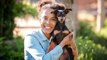 Tierreporterin Pia Amofa-Antwi hat einen Hund auf dem Arm | Bild: BR