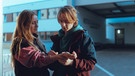 Zoe (Lena Klenke) lässt sich von Franz (Laurids Schürmann) seine Handynummer auf den Arm schreiben. | Bild: BR/Hager Moss Film GmbH/Luis Zeno Kuhn