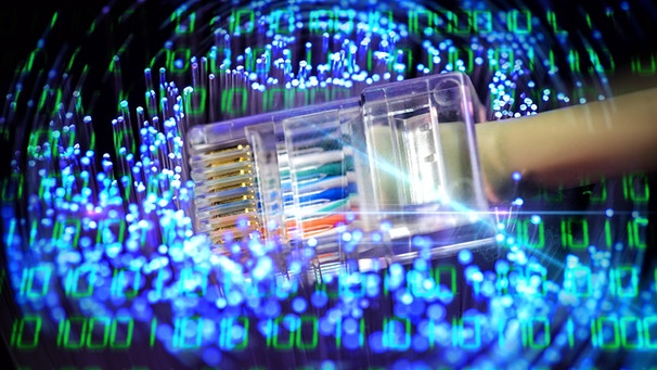 Ein Ethernet-STecker liegt auf dem Ende eines Glasfaserkabels. Symbolbild Datennetze | Bild: picture-alliance/dpa