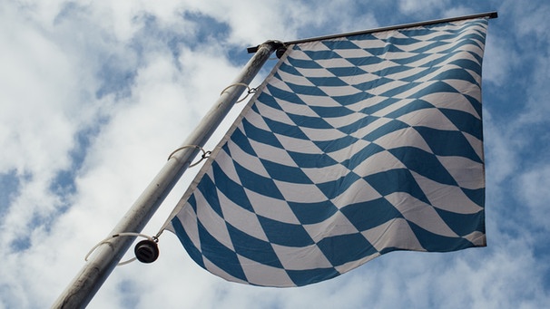 Die bayerische Flagge vor blauem Himmel. | Bild: BR/Johanna Schlüter