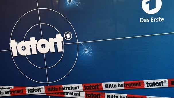 Auf einer Fotorückwand sind das Logo der ARD-Fernsehreihe "Tatort", Einschusslöcher und Absperrband abgebildet. | Bild: dpa-Bildfunk/Tobias Hase