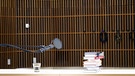 In einem Studio liegt ein Stapel Bücher auf einem Tisch. Ein Mikrofon steht bereit. | Bild: zehnseiten gmbh