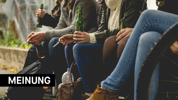 Jugendliche sitzen zusammen, trinken Alkohol und rauchen. | Bild: Adobe