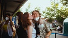Befreundete Besucher:innen umarmen sich bei PULS Storytime in München, während eine der beiden der anderen einen Kuss auf die Wange gibt. | Bild: BR/Kilian Seiler