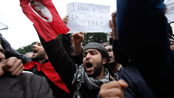 Demonstranten in Tunesien halten ein Transparent mit dem Spruch 'I have a dream, Tunisia free' in die Höhe | Bild: dpa/picture-alliance