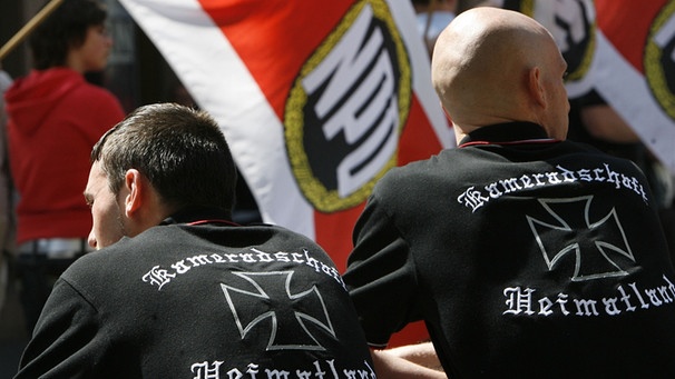 Zwei Rechtsextreme der "Kameradschaft Heimatland" nehmen am in Nürnberg an einem NPD-Aufmarsch teil. | Bild:  Daniel Karmann/picture-alliance/dpa