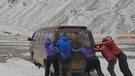 Bergsteiger schieben Auto durch Schnee um ins Basislager zu kommen | Bild: BR