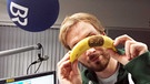 Moderator Ron mit einer tätowierten Banane | Bild: BR