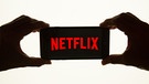 Netflix mit Hand | Bild: picture-alliance/dpa