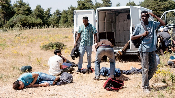 Als Amare (Joshua Edoze, vorne Mi.) und die anderen Flüchtlinge endlich aus dem Transporter ausbrechen, sind sie durstig und erschöpft. | Bild: © SWR/Pierre Meursaut
