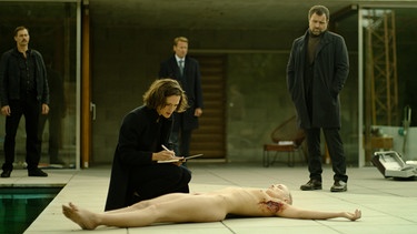 Szene aus der Serie "Parfum": eine Ermittlerinm kniet vor einer Leiche. | Bild: ZDF