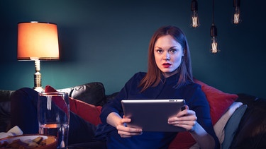 Skip Intro Folge 3 - Moderatorin Vanessa Schneider sitzt auf der Couch und schaut fasziniert | Bild: BR