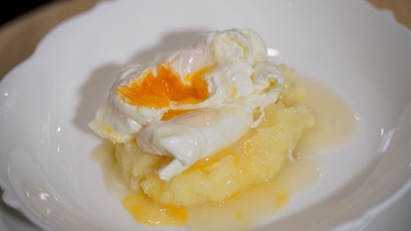 Auf einem Teller sind saure Eier auf Kartoffelpüree angerichtet. | Bild: BR