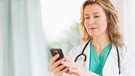 Ärztin benutzt ihr Smartphone | Bild: mauritius-images
