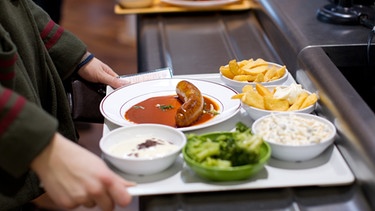 Auf einem Kantinentablett stehen Teller mit Mittagessen. | Bild: picture-alliance/dpa