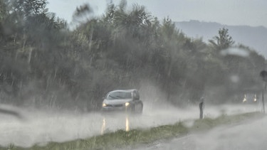 Auto bei starkem Regen auf einer Landstraße | Bild: picture-alliance/dpa