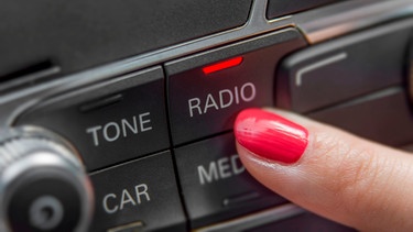 Finger drückt auf "Radio" im Auto | Bild: mauritius-images