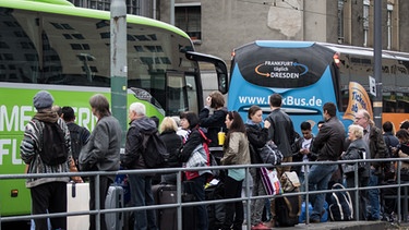 Menschen stehen dicht gedrängt an einem Fernbus, um einzusteigen. | Bild: picture-alliance/dpa