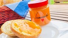 Schön fein durchpassierte Aprikosenmarmelade im Glas mit der Aufschrift "homemade", daneben eine Semmel mit der Marmelade bestrichen | Bild: BR