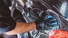 Hand mit Tuch reinigt ein Auto | Bild: mauritius images