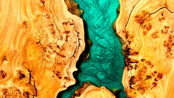 Türkises Epoxidharz füllt eine Lücke in einem Holzbrett | Bild: mauritius-images