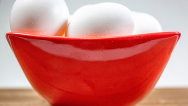 Eier liegen in einer roten Schüssel. | Bild: mauritius images / Juan Llauro / Alamy / Alamy Stock Photos