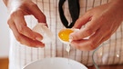 Frau trennt Eier beim Backen | Bild: mauritius-images
