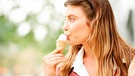 Frau isst Eis auf einem Spaziergang | Bild: mauritius images