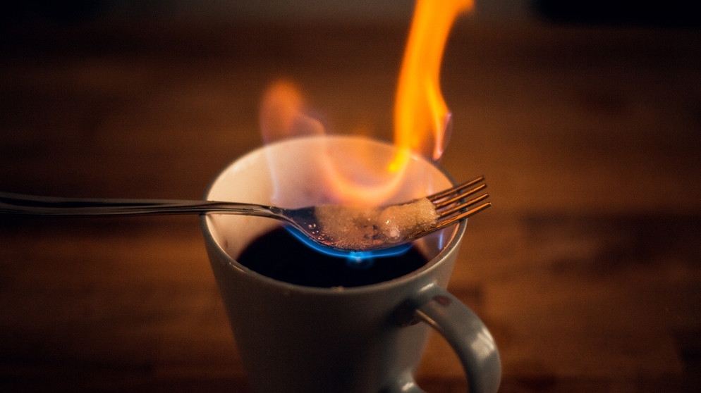 Auf einer Tasse liegen brennende Zuckerwürfel  | Bild: BR
