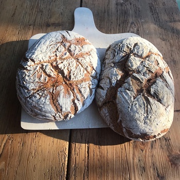 Zwei frisch gebackene Laibe Brot auf einem Holztisch | Bild: BR/ Susanne Wolff
