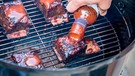 Mann verteilt Grillsauce auf Grillgut | Bild: mauritius images / Milton Cogheil / Alamy / Alamy Stock Photos