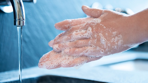 Eingeseifte Hände über einem Waschbecken | Bild: mauritius images