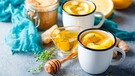 In zwei Bechern ist Wasser mit Zitronenscheiben. Ringsherum steht Honig, Ingwer und ein Thymianzweig. | Bild: mauritius-images