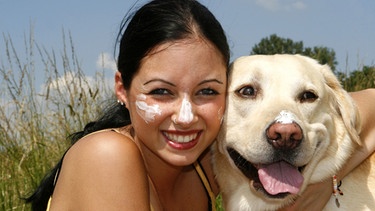 Hund hat Sonnencreme auf der Nase, ein Mensch Sonnencreme im Gesicht | Bild: picture-alliance/dpa