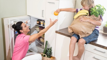 Frau und Kind vor Kühlschrank | Bild: mauritius-images