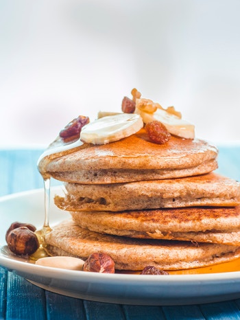 Low Carb-Pancakes auf einem Stapel mit Nüssen und Bananenscheiben | Bild: mauritius images