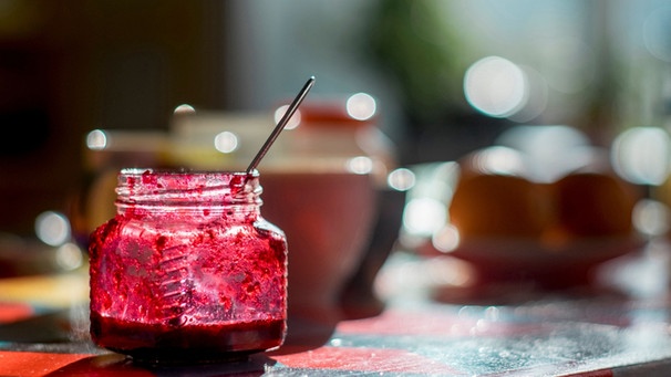 Glas mit Marmelade steht auf einem Tisch | Bild: mauritius images