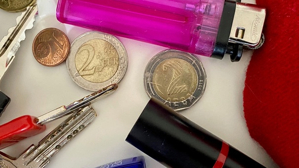 Münzen, Lippenstift, Feuerzeug und Schlüssel liegen auf einem Tisch | Bild: BR, Astrid Hickisch