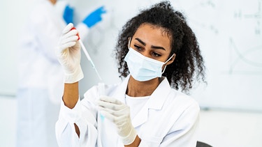Wissenschaftlerin arbeitet in einem Labor an einem Test während der Corona-Pandemie. | Bild: mauritius images