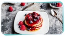 Stapel Pancakes mit Beeren auf einem Teller, über die Ahornsirup läuft | Bild: mauritius images