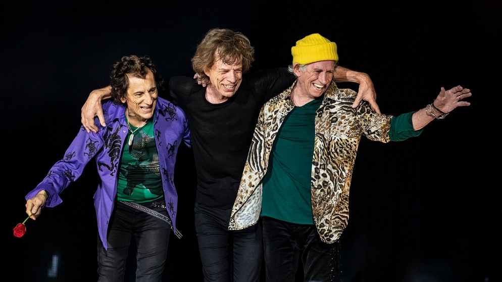 Die Rolling Stones, Ron Wood, Mick Jagger und Keith Richards, stehen Arm in Arm auf der Bühne  | Bild: J. Bouquet