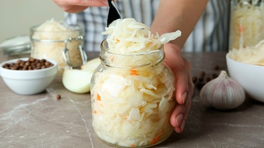 Frau fermentiert Sauerkraut | Bild: mauritius images