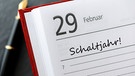 In einem aufgeschlagenen Kalender ist der 29. Februar mit "Schaltjahr" markiert. | Bild: BR - mauritius images / Chromorange / Christian Ohde