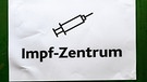 Der Aufdruck "Impfzentrum" und das Symbol eine Spritze auf einem aufgehängten Papier | Bild: dpa/picture alliance