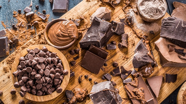 Schokolade auf einem Brett. | Bild: mauritius images / Tetra Images / Mike Kemp