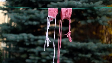 Zwei Stoffmasken hängen zum Trocknen auf einer Wäscheleine. | Bild: mauritius images
