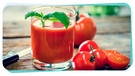 Ein Glas frischer Tomatensaft steht auf einem Holztisch, daneben liegen Tomaten | Bild: mauritius images