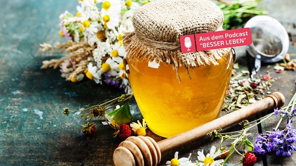 Ein Glas Honig, daneben liegen Blümchen | Bild: mauritius-images
