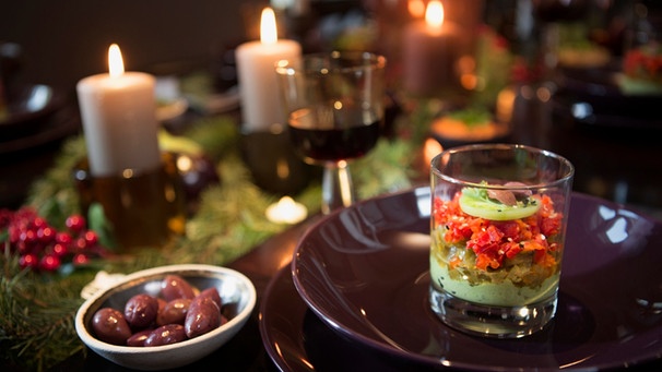 Auf einem festlich gedeckten Tisch steht eine Vorspeise, Wein und Oliven. | Bild: mauritius-images