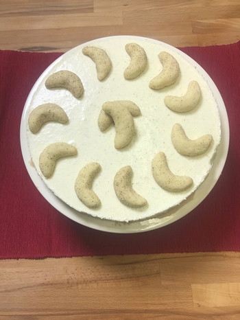 Eine cremige Torte mit Pannacotta-Füllung, auf der Vanillekipferl drapiert sind. | Bild: BR